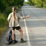 Hitchhiker catching car on highway