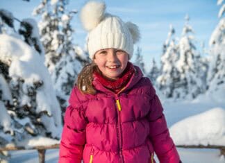 Portrait of a Beautiful Girl Delighting in Sunlight Amidst Snowy Peaks.