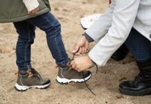 Alegeri inteligente pentru încălțămintea băieților – la ce să fii atent înainte de a cumpăra? Close up of mother helping her child tying the shoes