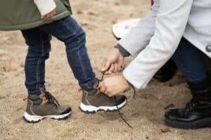 Close up of mother helping her child tying the shoes Close up of mother helping her child tying the shoes