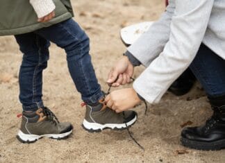 Alegeri inteligente pentru încălțămintea băieților – la ce să fii atent înainte de a cumpăra? Close up of mother helping her child tying the shoes